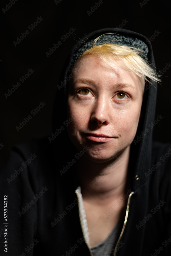 Fototapeta premium Portrait of a young woman with short blonde hair smiling upward.