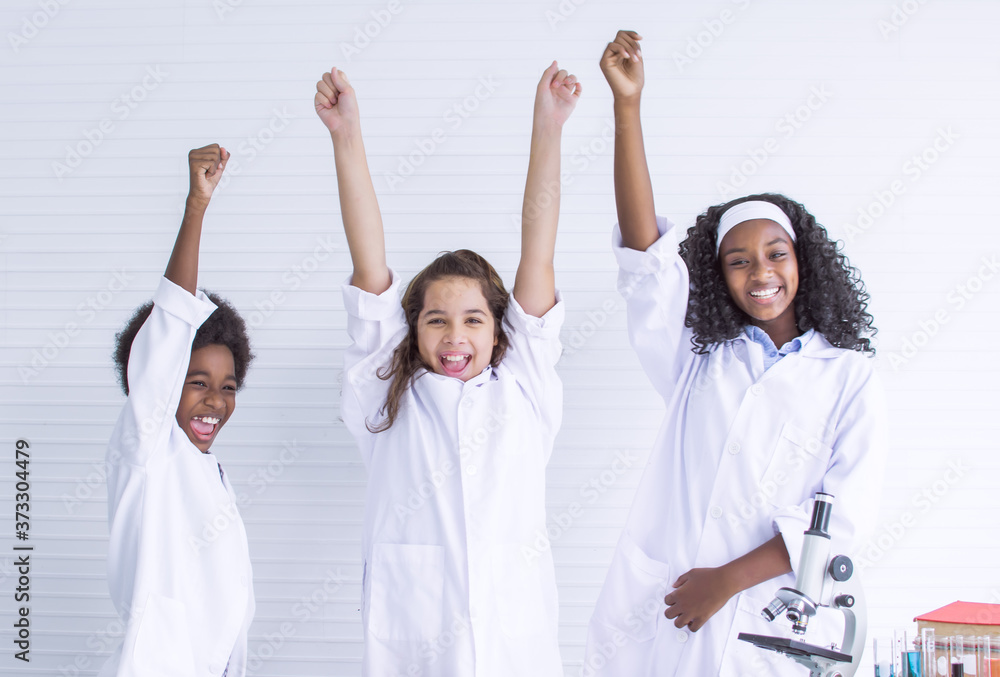 African and caucasian boy and girls rising their hands after success on their projects at school African and caucasian boy and girls rising their hands after success on their projects at school