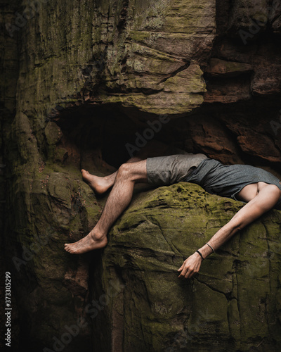 Climber pausing on a rock while climbing a mountain.