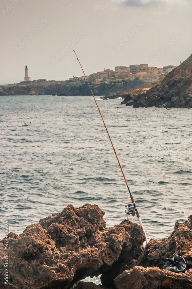fishing rods held in fishing rod holders in front of the sea with nice background fishing rods held in fishing rod holders in front of the sea with nice background