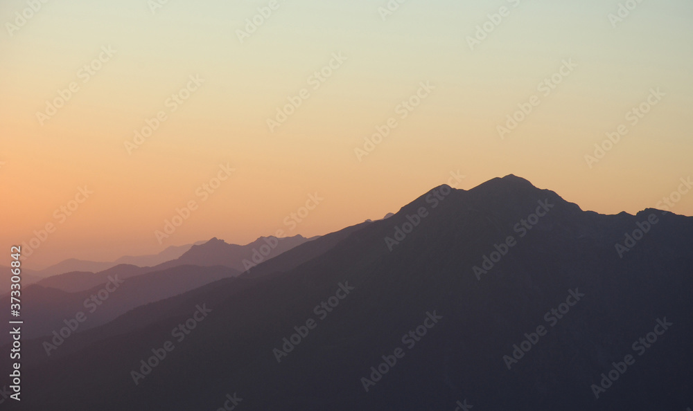 sunset in mountains. peaks and hills against clean sky