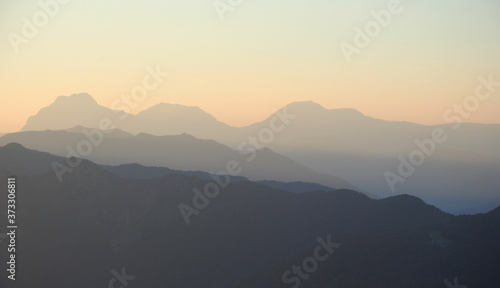 sunset in mountains. peaks and hills against clean sky