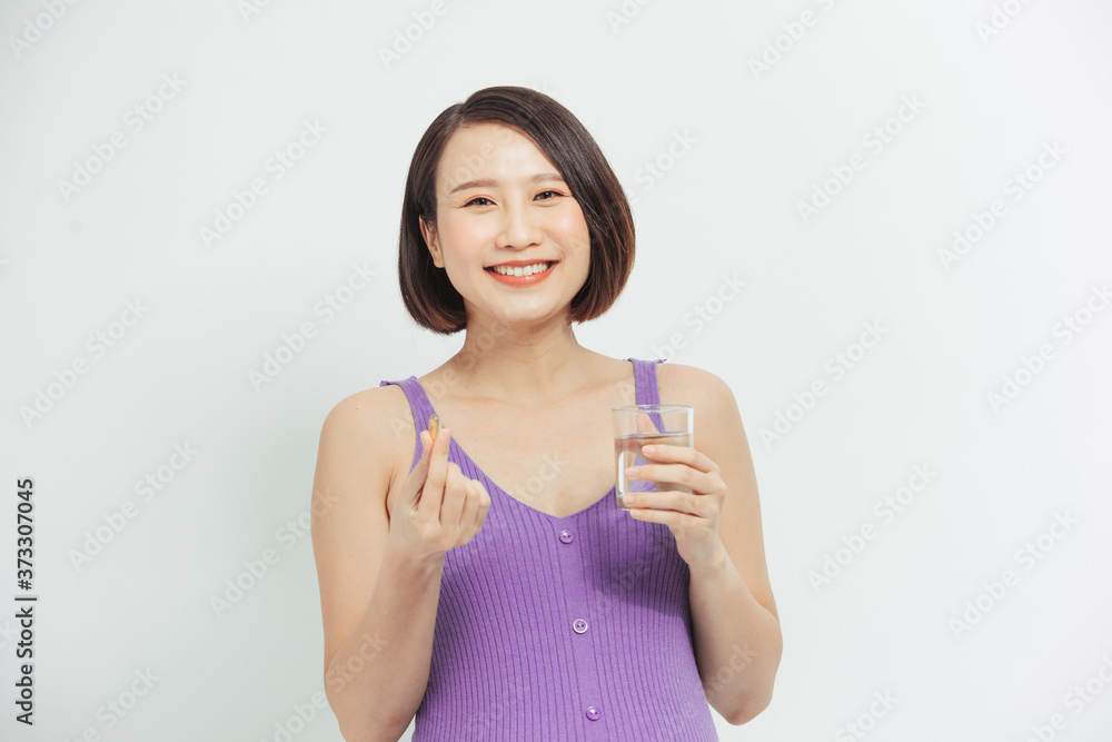 Young pregnant woman holding glass of water and pill. Young pregnant woman holding glass of water and pill.