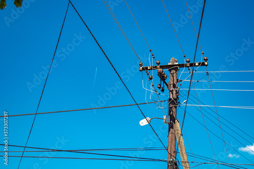 power lines and a plane on a blue sky