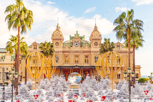 Monte Carlo Casino in Monaco, Cote de Azur, Europe. View of Grand Theatre, office of Les Ballets de Monte Carlo in winter. white Christmas tree, red gift boxes and New Year decorations.