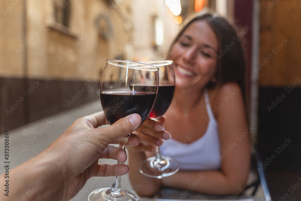 a happy woman drinks a glass of red wine with her boyfriend in the restaurant