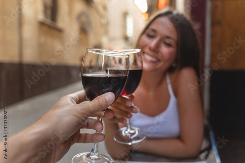 a happy woman drinks a glass of red wine with her boyfriend in the restaurant