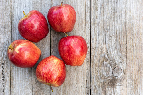 Red apples on a wooden background. Copy space.