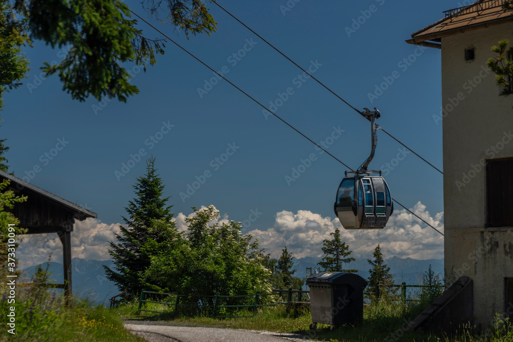 Cable car Kanzelhohe in green needles forest in summer sunny day Cable car Kanzelhohe in green needles forest in summer sunny day