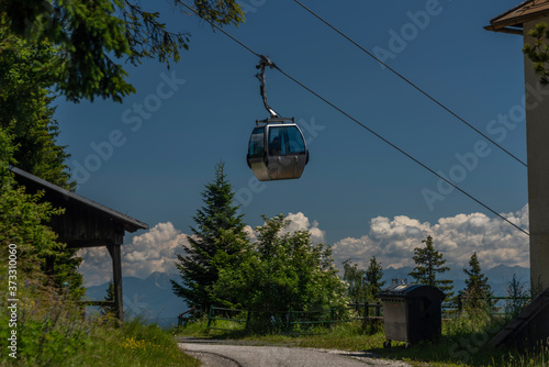 Cable car Kanzelhohe in green needles forest in summer sunny day