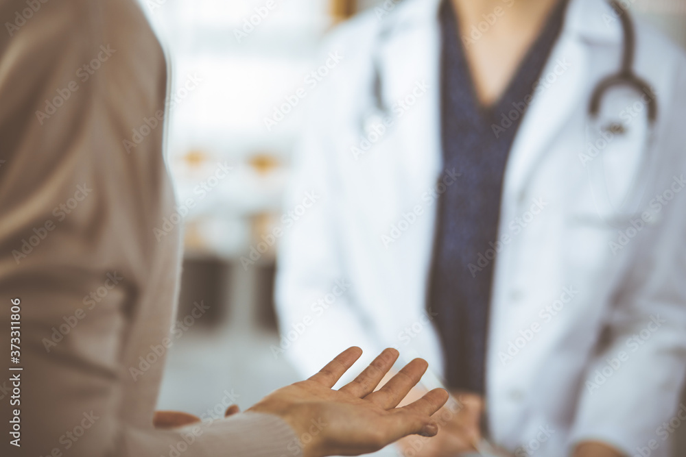 Doctor and patient discussing current health examination while sitting in clinic. Perfect medical service in hospital Doctor and patient discussing current health examination while sitting in clinic. Perfect medical service in hospital
