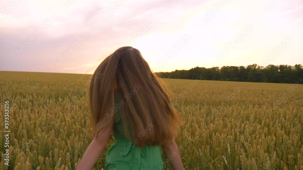 A beautiful teenager runs through a green field. Long hair develops in the wind. A girl in a green dress enjoys life, clean air. A happy child runs forward to a dream, rejoicing in a new day. A beautiful teenager runs through a green field. Long hair develops in the wind. A girl in a green dress enjoys life, clean air. A happy child runs forward to a dream, rejoicing in a new day.