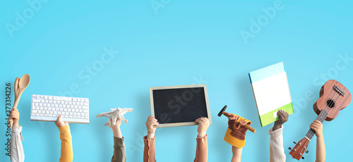 Children are holding books, toys, and a keyboard. Educational concept photo