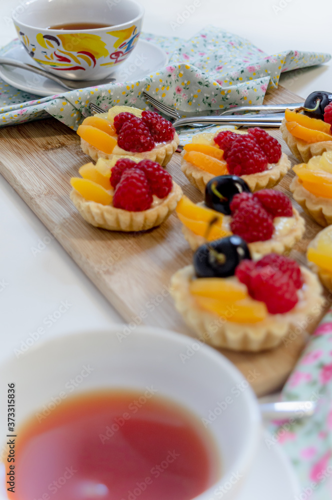 fruit tartlets being served with cups of tea fruit tartlets being served with cups of tea