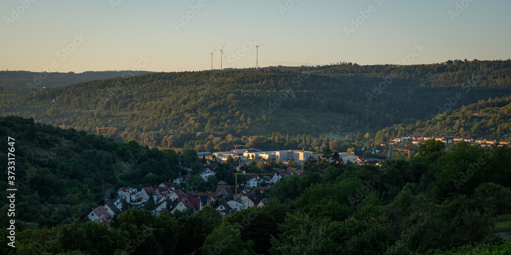 German village with forest and wind power turbines
