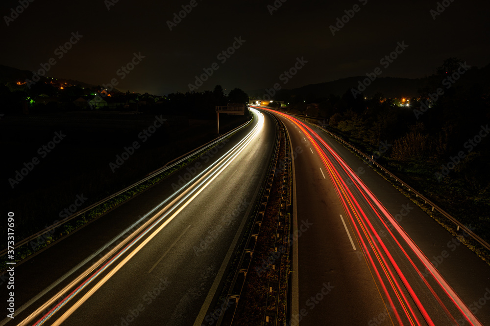 Car light trails on a highway in night