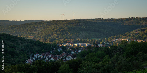 German village with forest and wind power turbines