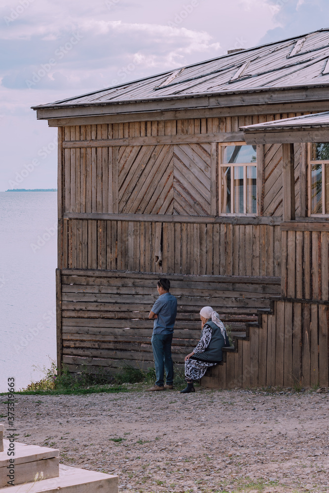 wooden house on the shore with people