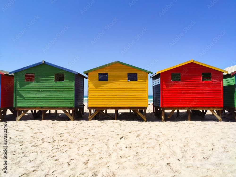Three colorful beach houses on the beach at Muizenberg frontal - South Africa, Eastern Cape Three colorful beach houses on the beach at Muizenberg frontal - South Africa, Eastern Cape