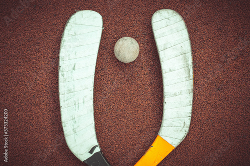 Cuadro en lienzo A hockey stick and a wooden dribbling ball on a red background