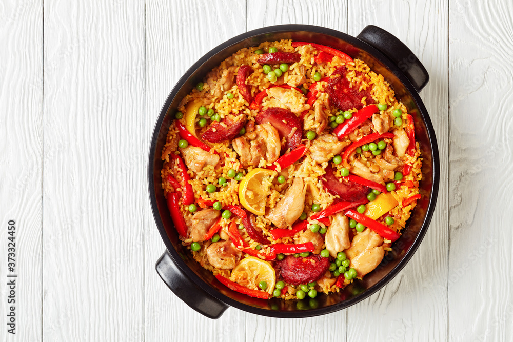 spanish chicken paella in a black dish spanish chicken paella in a black dish