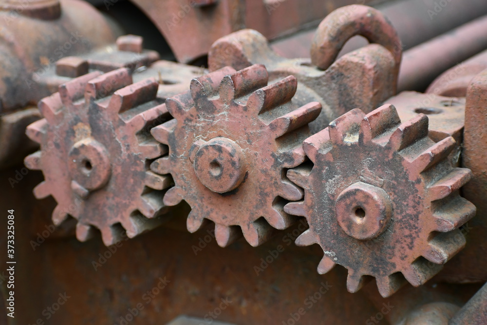 Rusted spur gears on vintage logging equipment.
