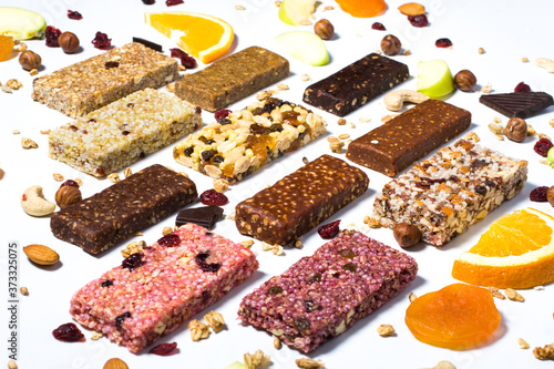 Composition with cereal granola and protein bars with nuts and dry fruit berries on the white backround