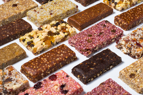 Composition with cereal granola and protein bars with nuts and dry fruit berries on the white backround