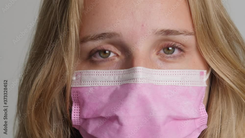 Young blond caucasion girl puts on pink mouth mask pan right 4k 50fps Young blond caucasion girl puts on pink mouth mask pan right 4k 50fps