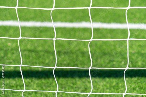 Close up of football soccer goal net with green grass background