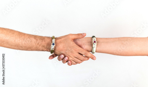 Hands of a couple of man and woman touching each other, wearing luxurious jade bracelets.