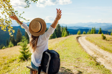 Trip to Carpathian mountains. Woman hiker relaxing admiring landscape with arms raised. Traveling in summer Ukraine