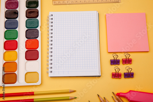 School supplies on yellow background. Back to school abstract background. Creative flat lay with copy space.