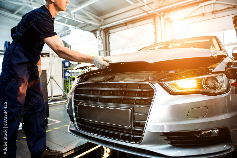 Fototapeta premium Car mechanic repair engine at service station. Car repair