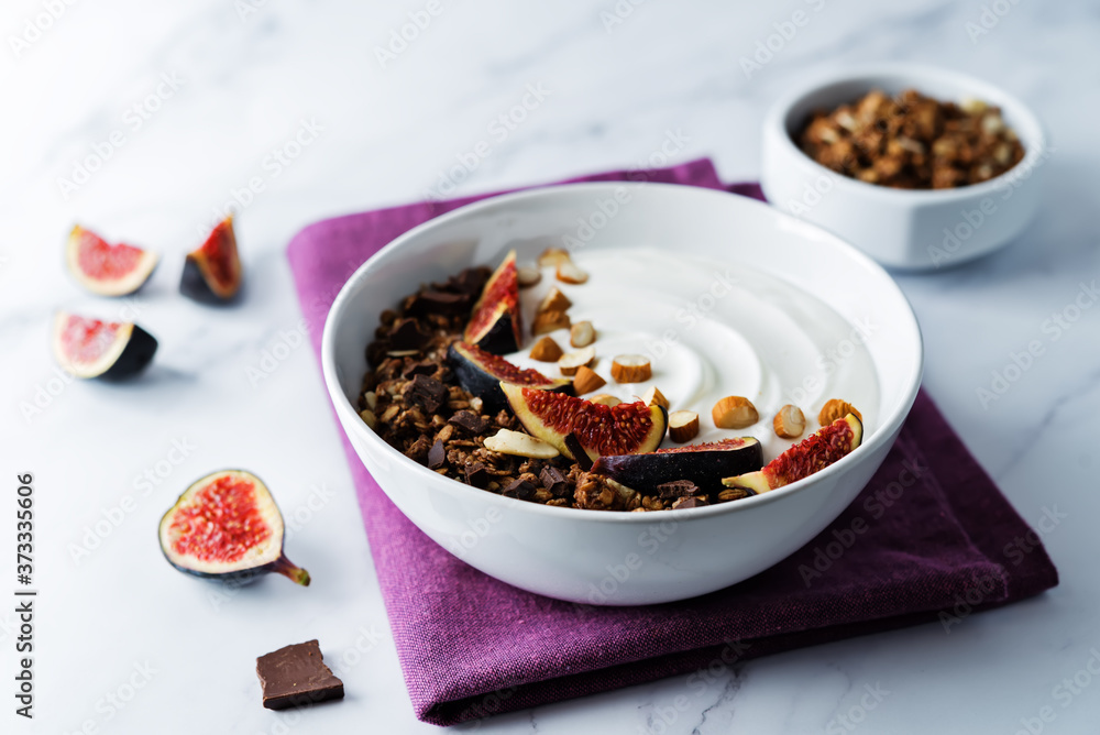 Greek yogurt chocolate almond nuts oatmeal granola with figs in a bowl Greek yogurt chocolate almond nuts oatmeal granola with figs in a bowl