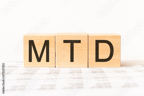 Word MTD - Month To Date acronym. Wooden small cubes with letters isolated on white background with copy space available. Business Concept image.