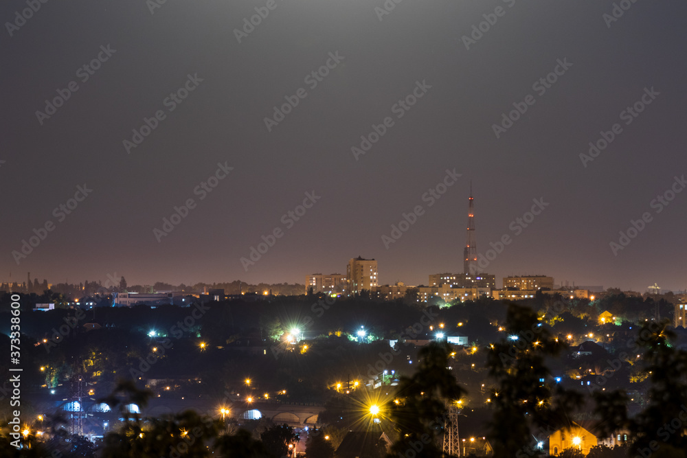 Night time city lights panorama. Big city lightened with bright moon light. Colorful romantic clear sky night view on Kharkiv, Ukraine