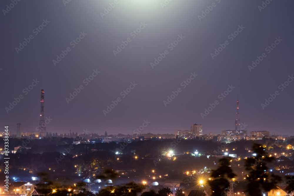 Night time city lights panorama in purple romantic colors. Big city lightened with bright moon light. Colorful moody clear sky night view on Kharkiv, Ukraine