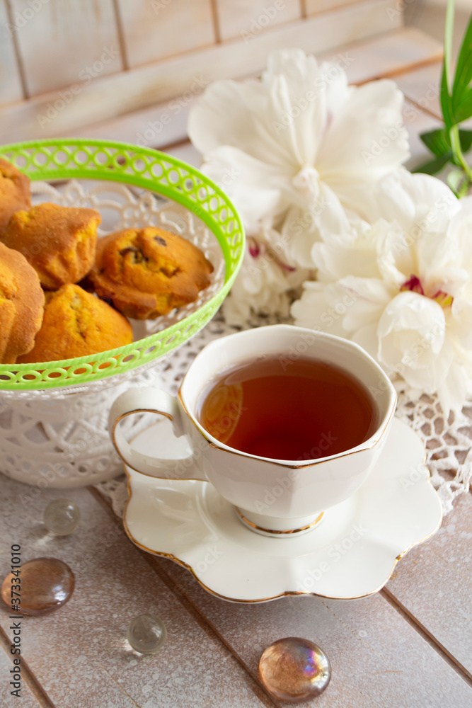 Afternoon tea served with a cupcakes, shabby table with white peony Afternoon tea served with a cupcakes, shabby table with white peony