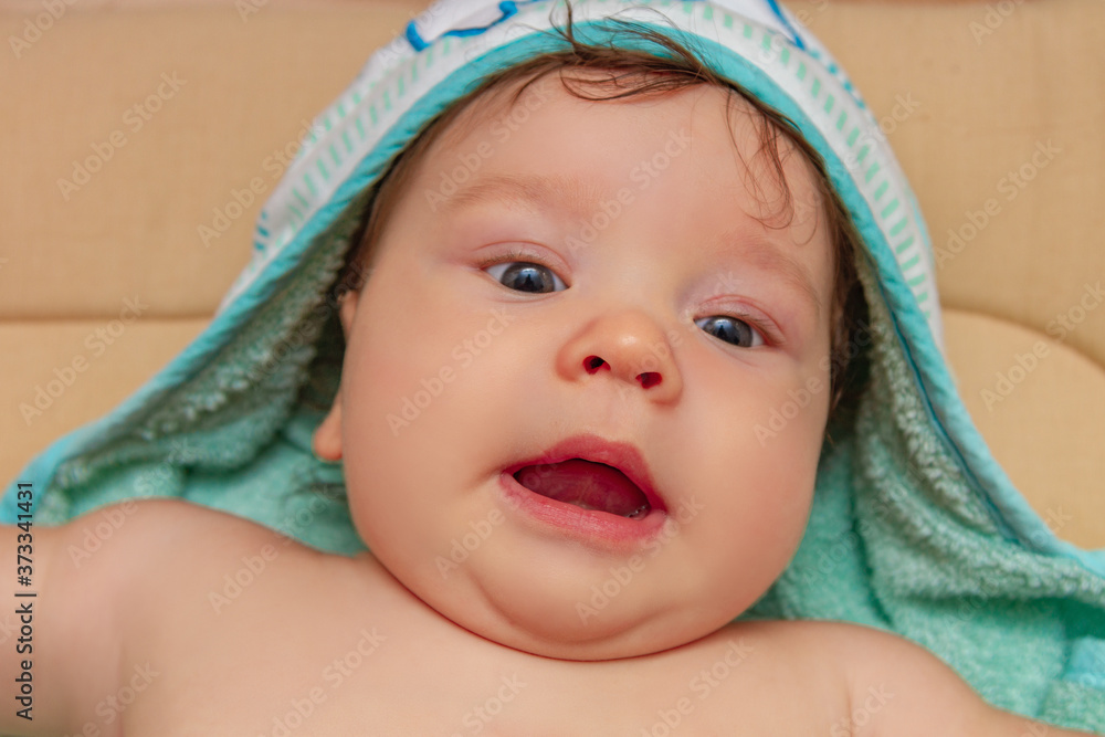 Close up portrait of a baby in a towel lying on the changing table. Close up portrait of a baby in a towel lying on the changing table.