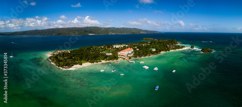 Aerial drone panorama view of the paradise island with white sand beach, blue water, resort hotel and boats around, Cayo Levantado, Dominicana