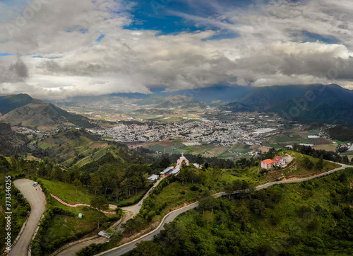Aerial drone view of Jesus baby statue (Divino Niño), mountains and valley with city Constanza, Dominican Republic  photo