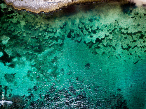 Aerial drone view of transparent water of Caribbean Sea and coral reef floor at the bottom near Saona Island, Dominican Republic 