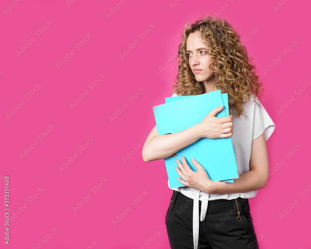 A young woman holds folders with documents in her hands. A young woman holds folders with documents in her hands.