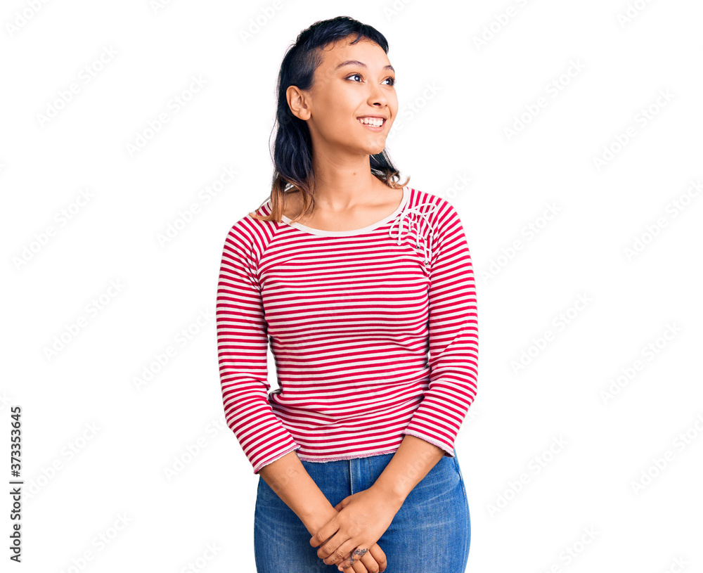 Young woman wearing casual clothes looking away to side with smile on face, natural expression. laughing confident. Young woman wearing casual clothes looking away to side with smile on face, natural expression. laughing confident.