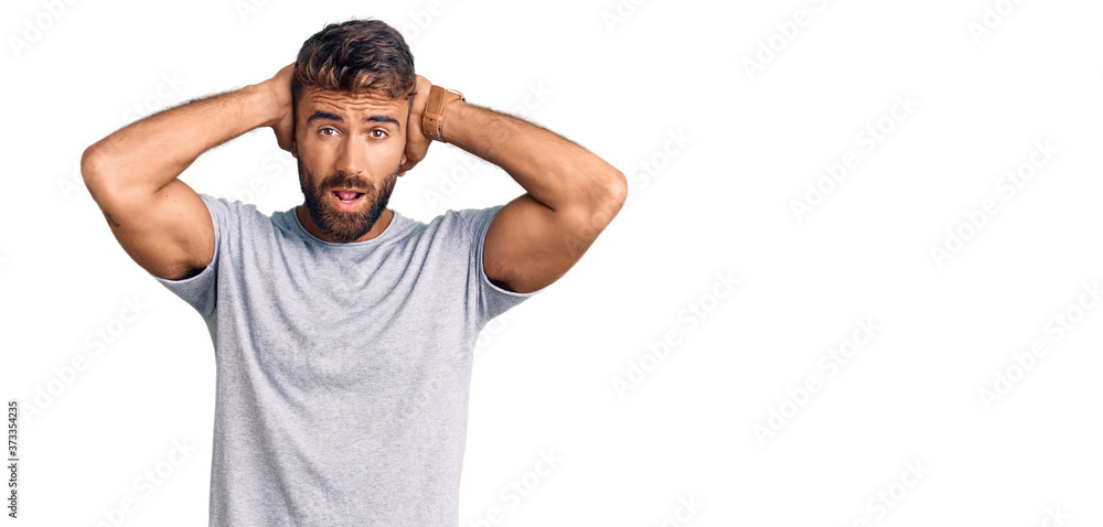 Young hispanic man wearing casual clothes crazy and scared with hands on head, afraid and surprised of shock with open mouth Young hispanic man wearing casual clothes crazy and scared with hands on head, afraid and surprised of shock with open mouth
