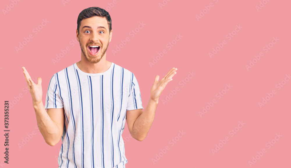 Handsome young man with bear wearing casual clothes celebrating victory with happy smile and winner expression with raised hands Handsome young man with bear wearing casual clothes celebrating victory with happy smile and winner expression with raised hands