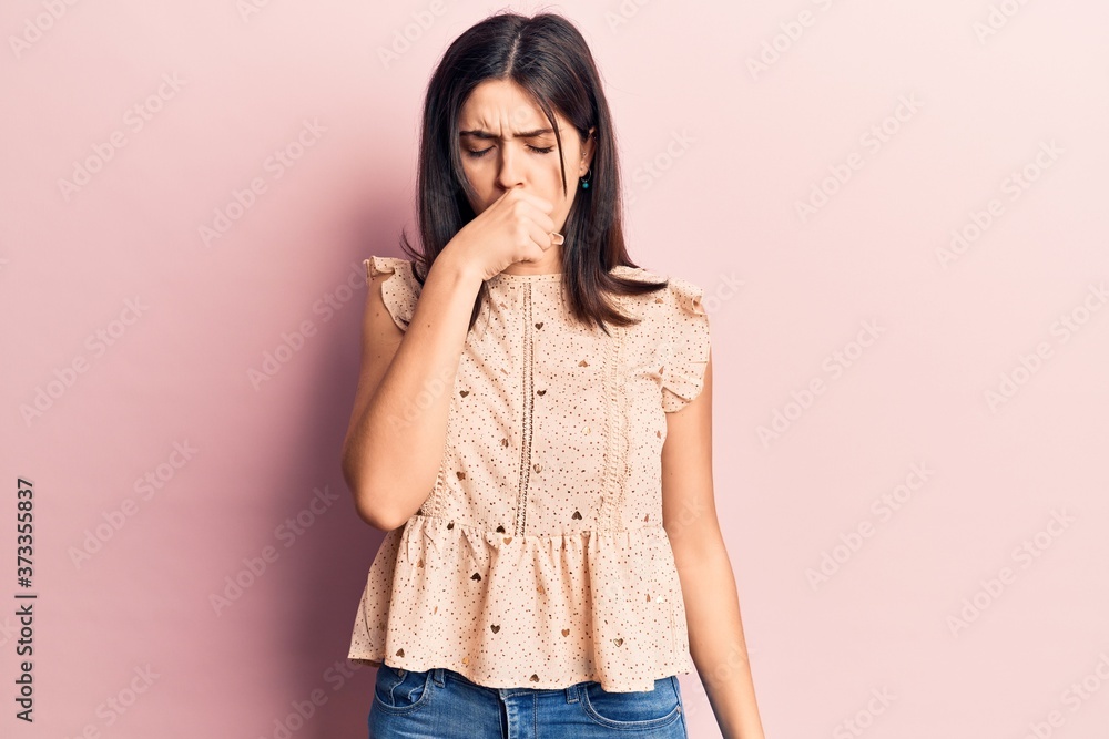Young beautiful girl wearing casual sleeveles t shirt feeling unwell and coughing as symptom for cold or bronchitis. health care concept. Young beautiful girl wearing casual sleeveles t shirt feeling unwell and coughing as symptom for cold or bronchitis. health care concept.