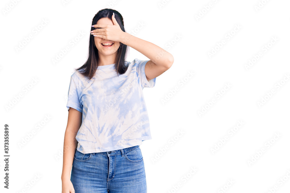 Fototapeta premium Young beautiful girl wearing casual t shirt smiling and laughing with hand on face covering eyes for surprise. blind concept.