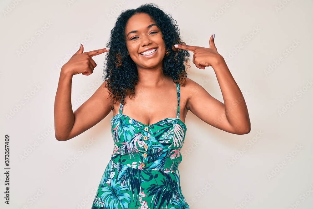 Young african american woman wearing casual clothes smiling cheerful showing and pointing with fingers teeth and mouth. dental health concept. Young african american woman wearing casual clothes smiling cheerful showing and pointing with fingers teeth and mouth. dental health concept.